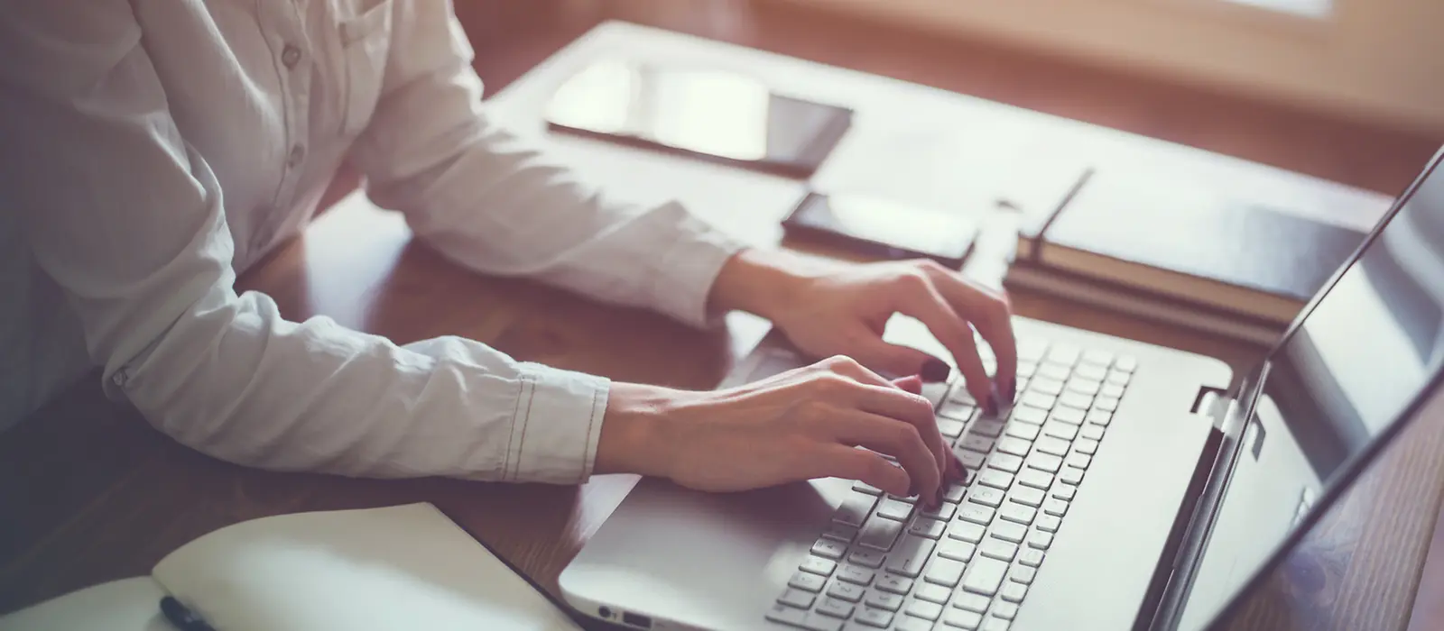 Eine Frau tippt auf einer Laptop-Tastatur