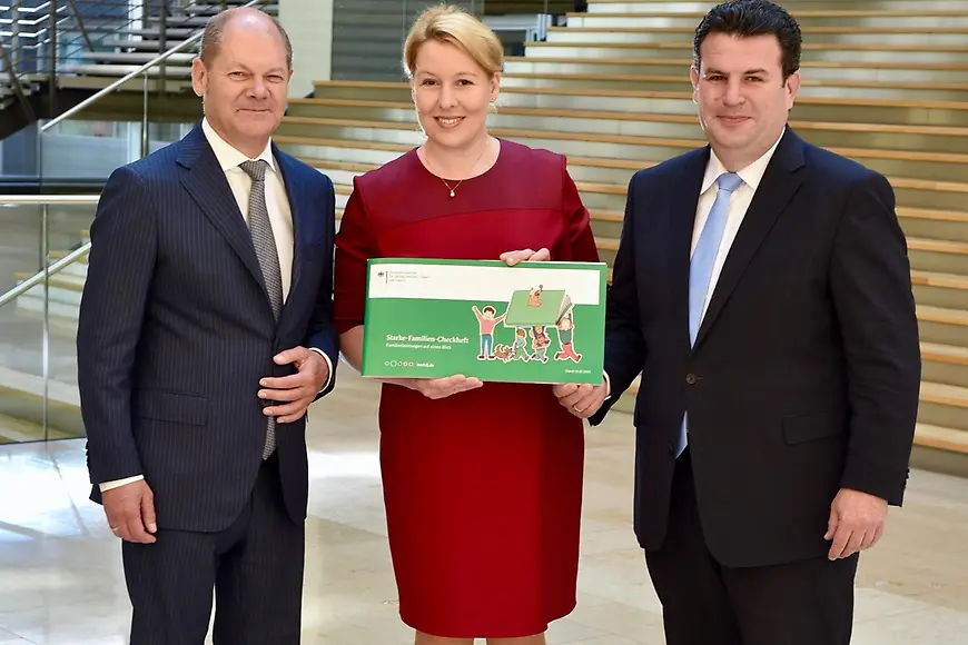 Dr. Franziska Giffey, Olaf Scholz und Hubertus Heil das neue Starke-Familien-Checkheft hoch