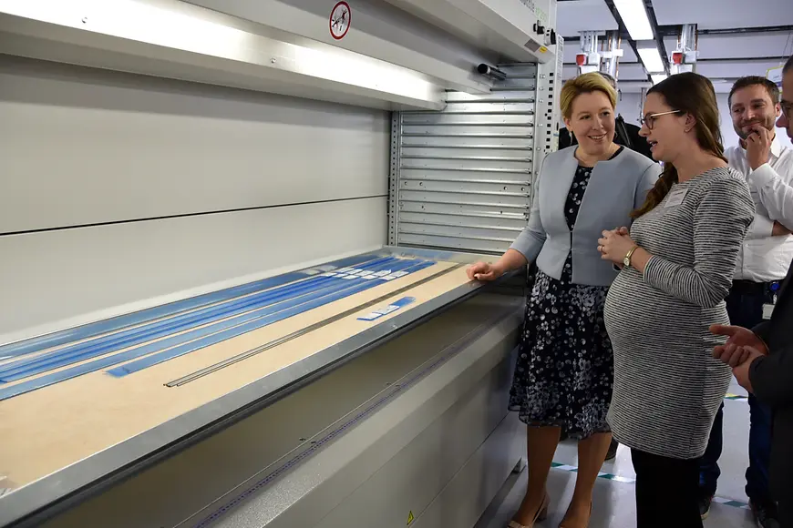 Dr. Franziska Giffey steht mit einer Mitarbeiterin von Cotronik vor einem Regal mit Produkten des Unternehmens.