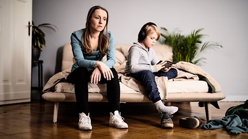 Mutter und Sohn sitzen mit Abstand auf dem Sofa