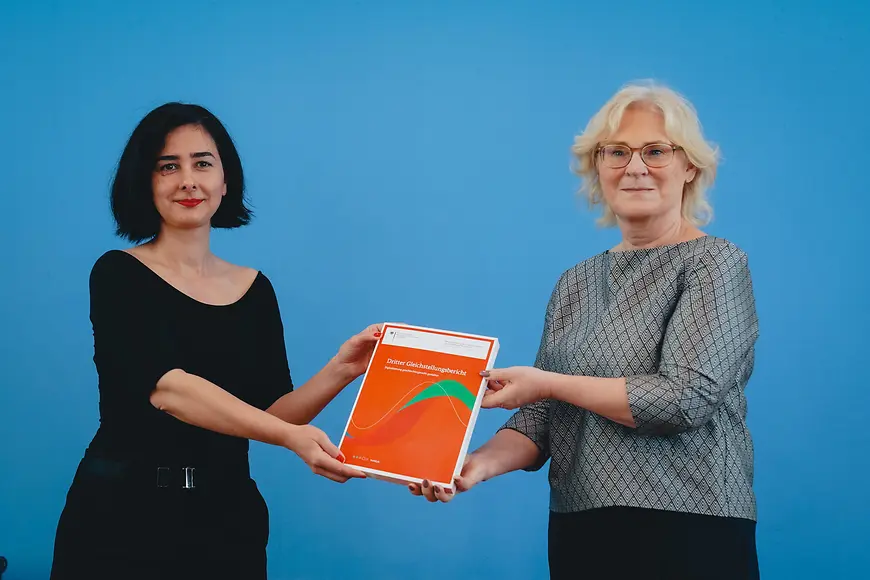 Christine Lambrecht und Aysel Yollu-Tok halten den Dritten Gleichstellungsbericht hoch