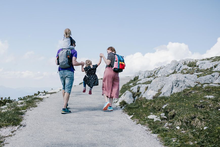 Eine junge Familie im Urlaub beim Wandern auf einen Berg