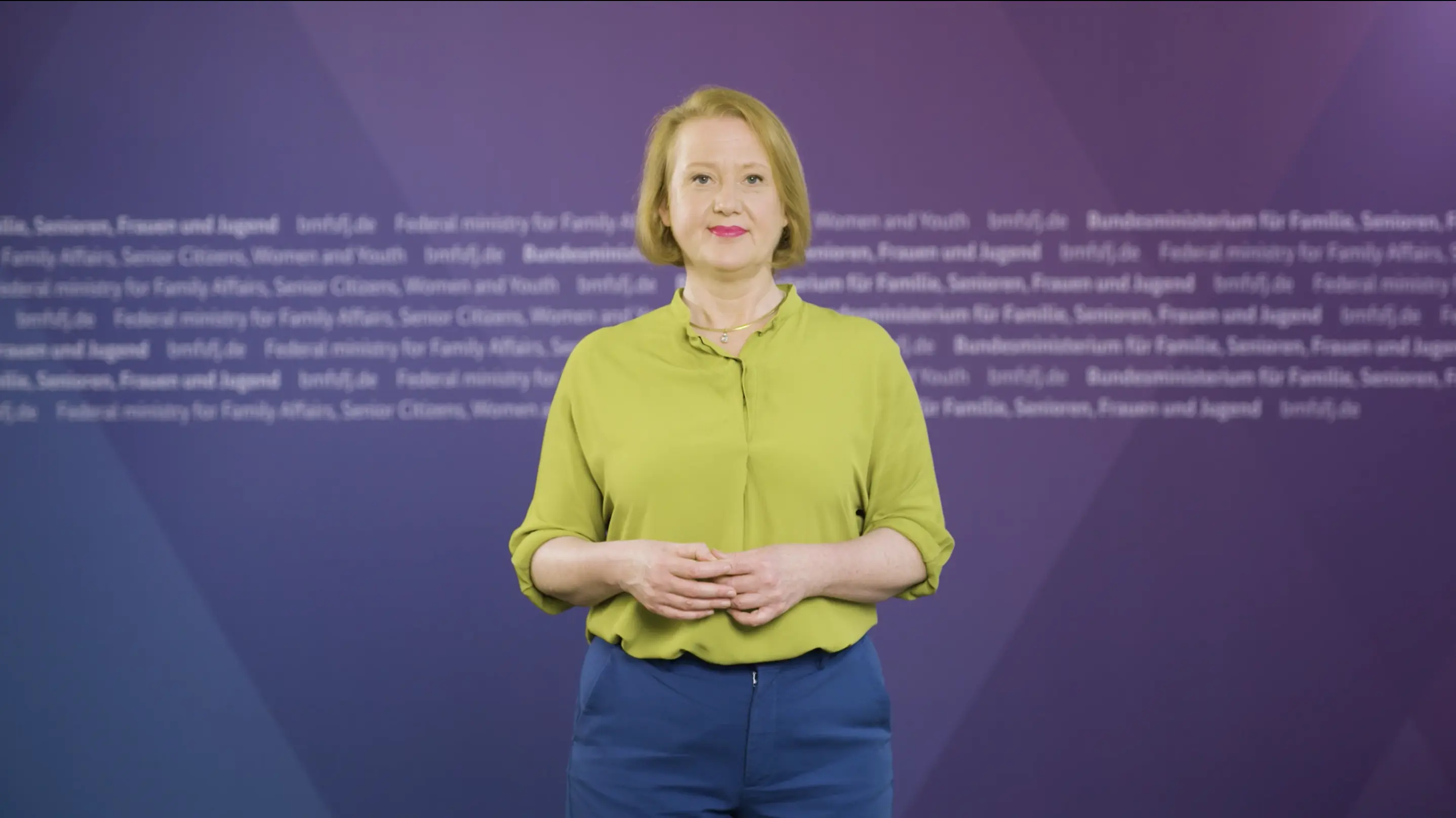 Lisa Paus vor einer Pressewand im Ministerium