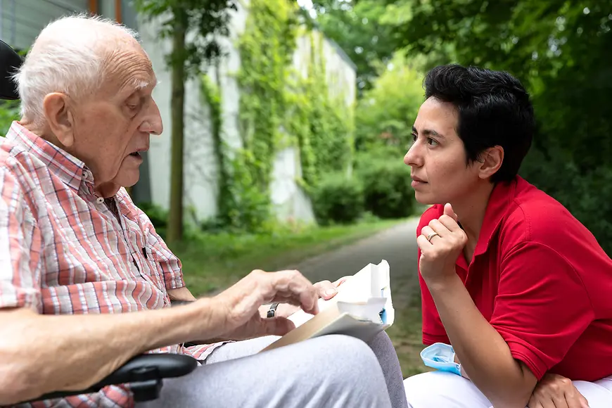 Ein älterer Mann liest jemandem vor