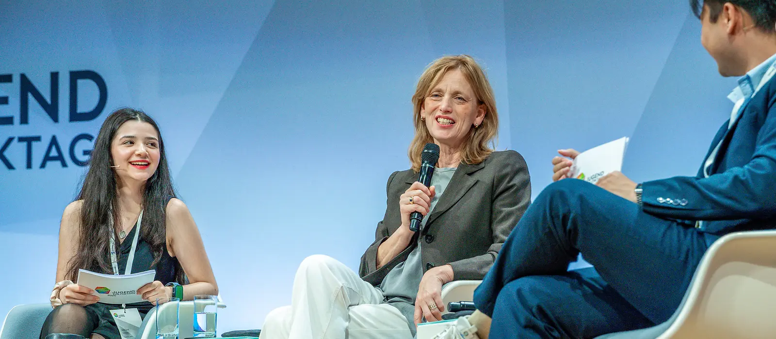 Karin Prien sitzt mit weiteren Teilnehmenden der JugendPolitikTage auf einer Bühne 