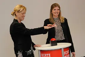 Karin Prien drückt feierlich auf einen Buzzer