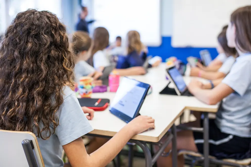 In einem Klassenraum arbeiten Kinder an Tablets