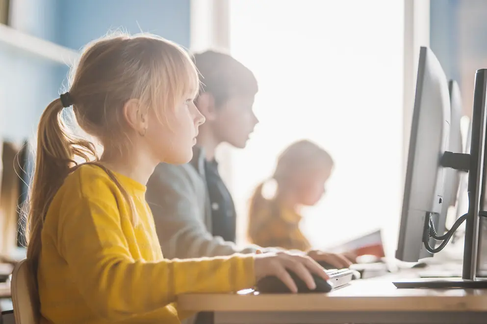 Eine junge Schülerin schaut konzentriert auf einen Computer Bildschirm