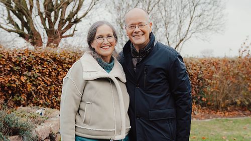 Ein älteres Paar vor einem Bambus im Garten