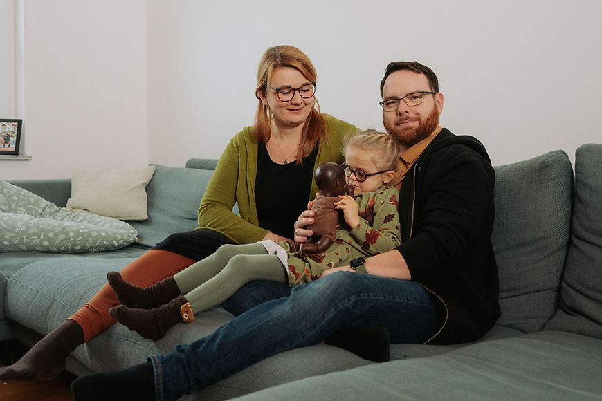 Ein junges Paar mit Tochter auf der Couch