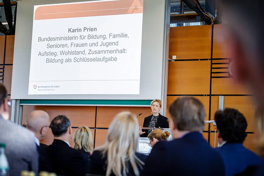 Karin Prien an einem Rednerpult vor Menschen