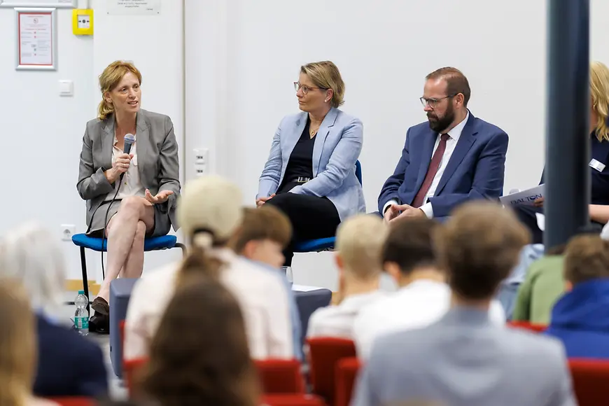 Karin Prien, Stefanie Hubig und Gordon Hoffmann vor einer Gruppe von Schülern