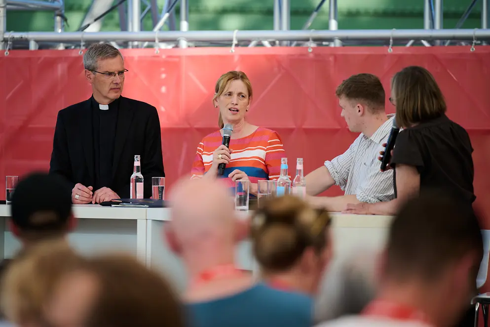 Karin Prien im Gespräch mit anderen Menschen auf dem Caritas-Emüfang