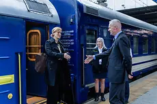 Karin prien steigt aus einem blauen Zug aus 